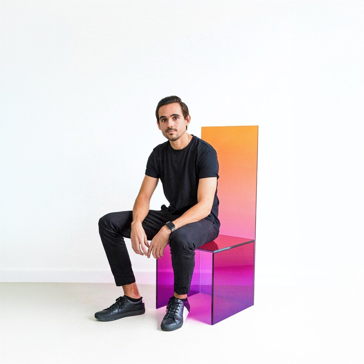 Guillermo Pernia, fundador y director de Pernia Glass y Glass Lab, sentado en una silla de vidrio de degradado tornasolado
