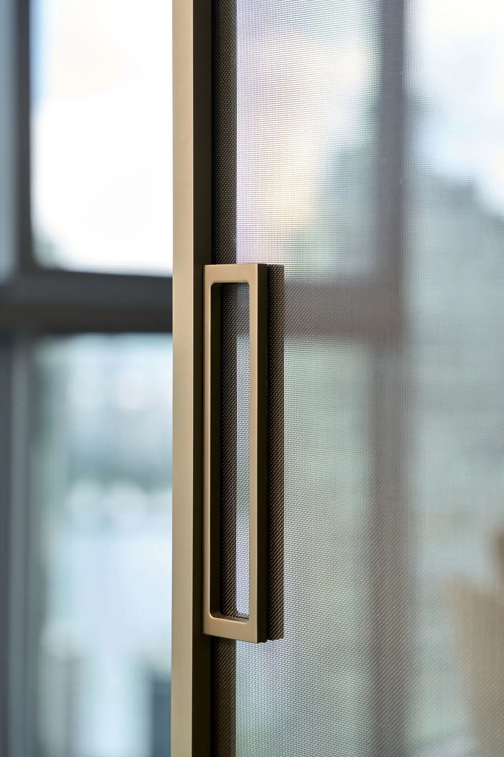 Detalle del perfil slim anodizado y su tirador embutido en un sistema Pernia Glass